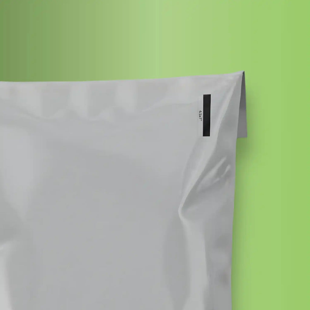 corner of 100% grey mailing bag on green background