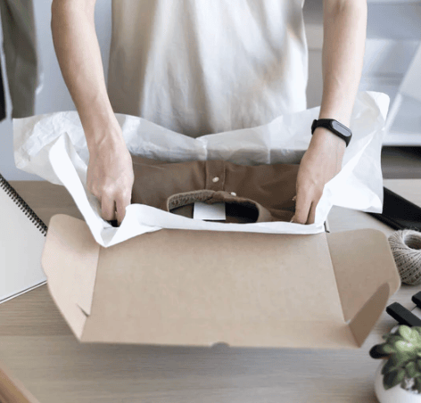 Person packing items into an SR eco-friendly cardboard box