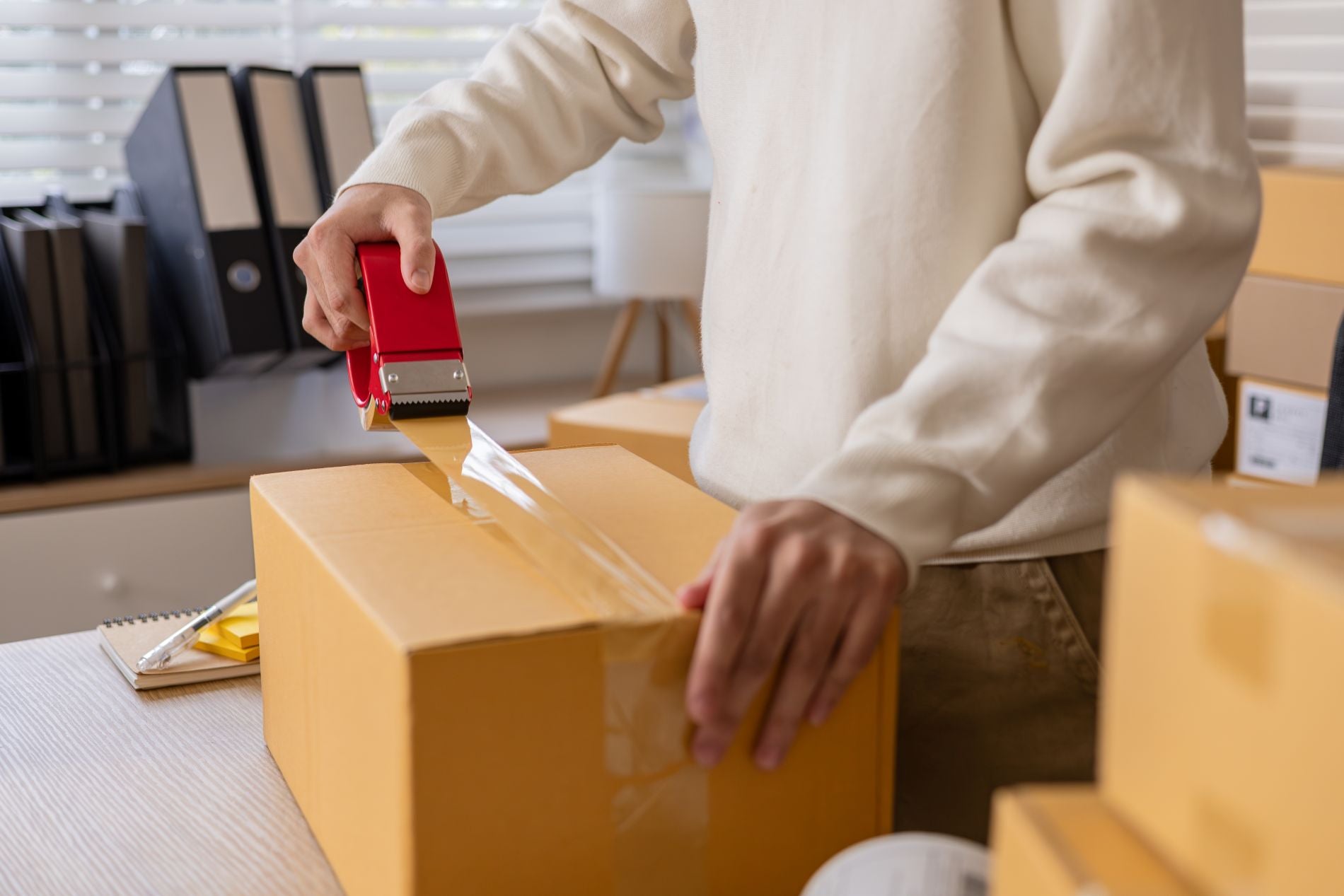 sealing cardboard box with packaging tape