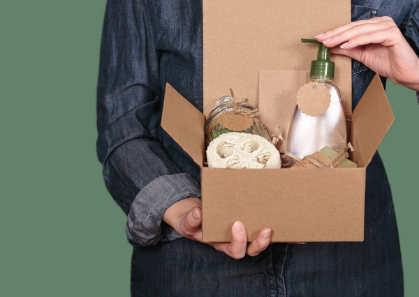 Person holding items in an SR eco-friendly cardboard box